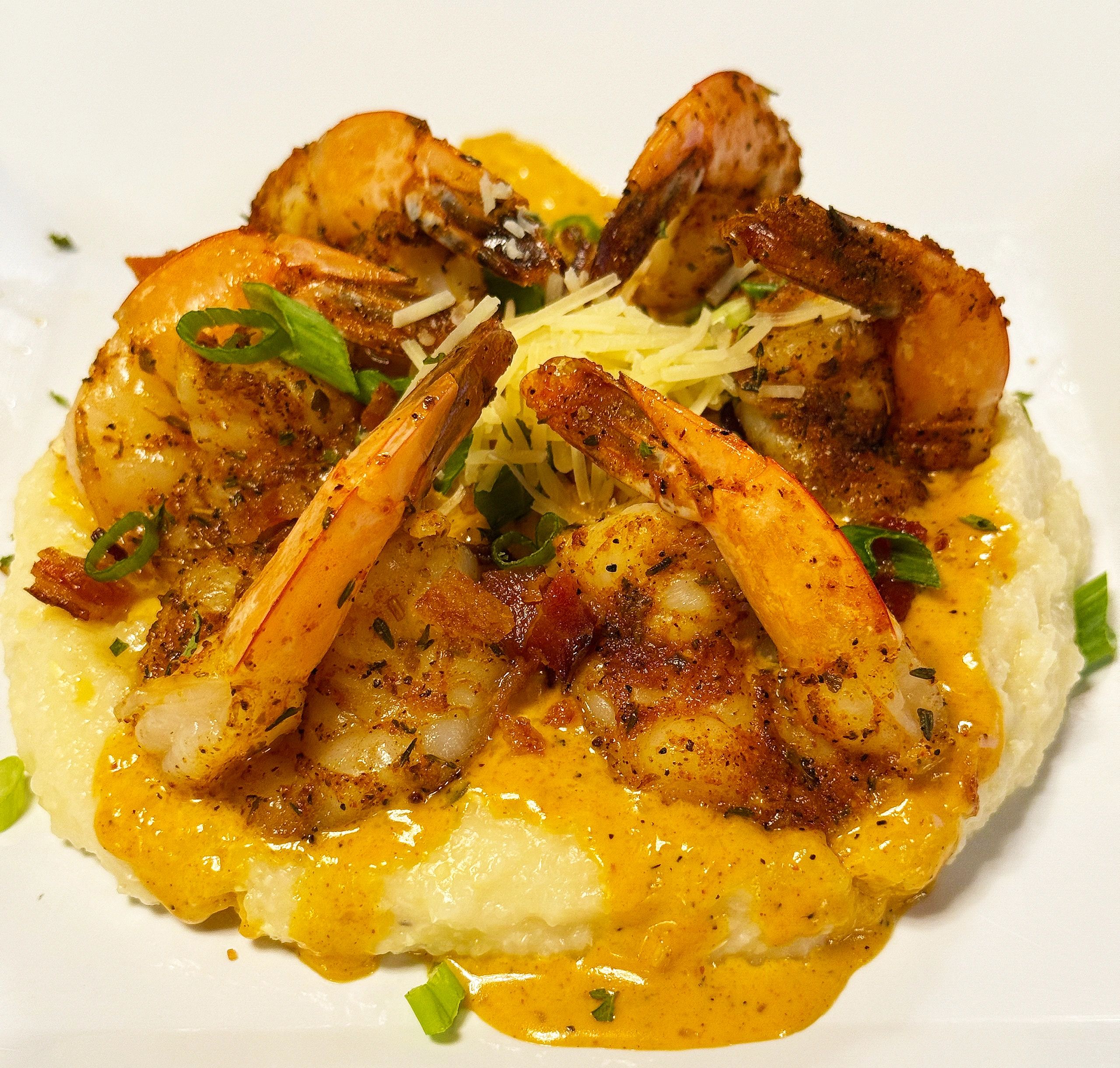 Seasoned shrimp served over creamy grits with cheese and green onions.