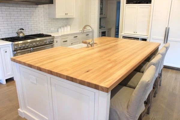 Modern white kitchen with maple island countertop