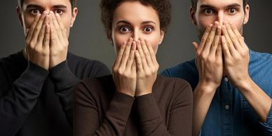 Three surprised people covering their mouths with their hands.