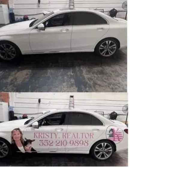 White car with realtor advertisement on the side.