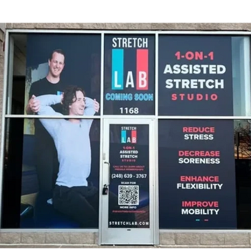 Storefront window advertising a 1-on-1 assisted stretch studio called Stretch Lab.