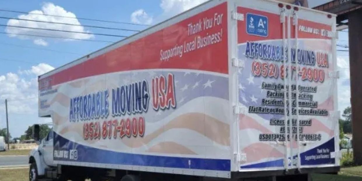 A large moving truck with Affordable Moving USA branding parked on grass.