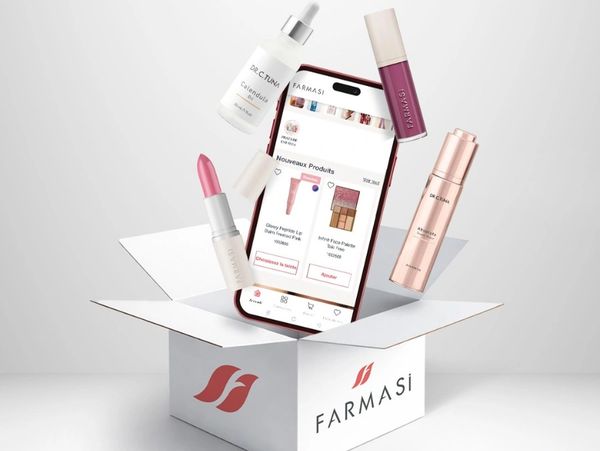 Farmasi beauty products and phone emerging from a branded box.