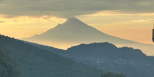 Volcán al atardecer con un poco de nube en la cima.