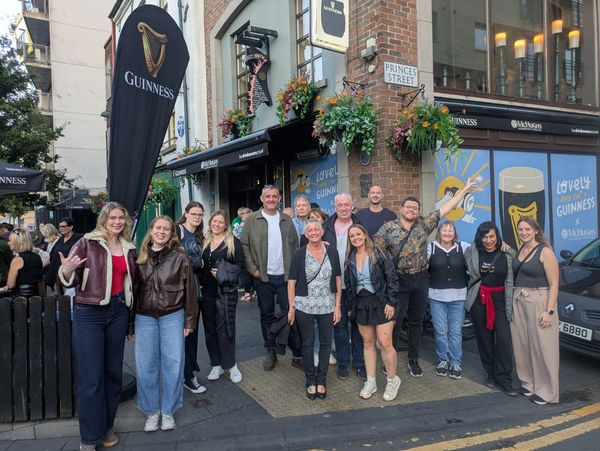 Group of people posing outside a Guinness pub on Princes Street.