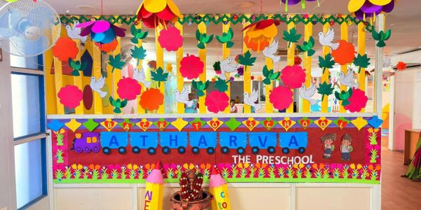 Colorful preschool entrance decorated with flowers and a train theme.