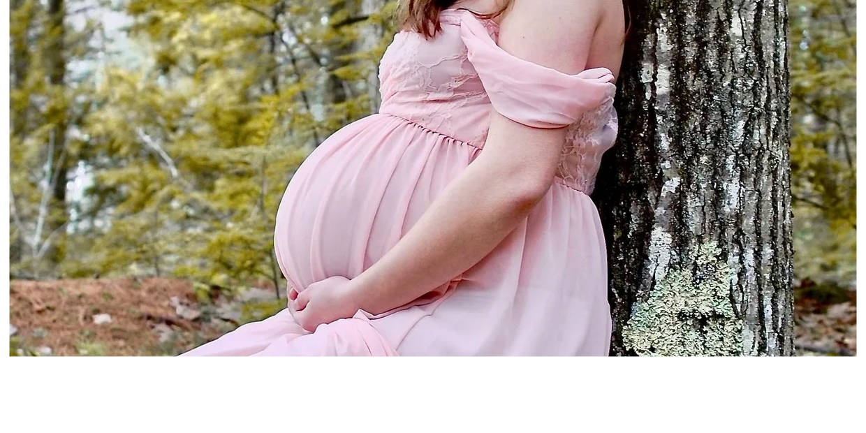 Schwangere Frau im pinken Kleid im Wald
