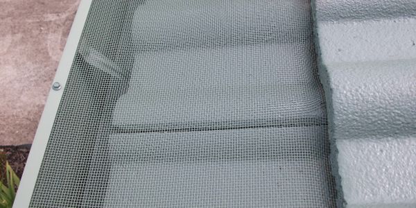 Close-up of a metal mesh screen covering a corrugated surface outdoors.