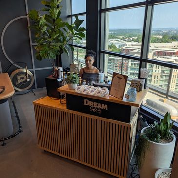 Woman at a coffee stand inside a modern office building.