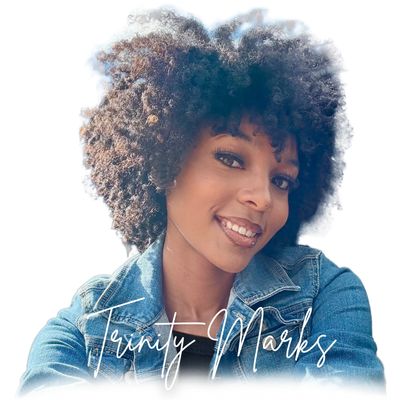 Smiling woman with curly hair in a denim jacket.
