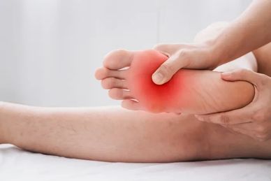 Image of a hand grabbing a foot with red indicating the pain site under the ball of the foot. 