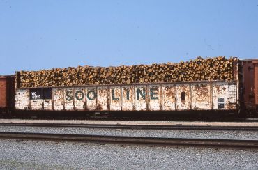 Railcar loaded with cut logs with Soo Line branding.