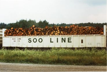 Train car loaded with logs labeled SOO LINE.