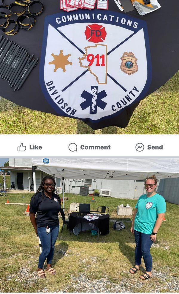 Davidson County 911 Communications booth with two smiling representatives outdoors.