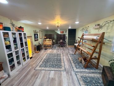 Craft room with yarn and weaving tools.