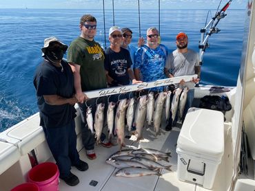 Lake Michigan Charter fishing trip with group of 6 guys holding full rack of Coho Salmon and Lakers