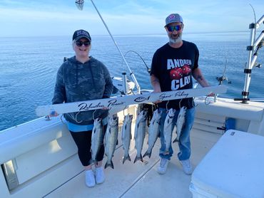 Couple catching their Coho Salmon during Lake Michigan Charter Fishing Trip