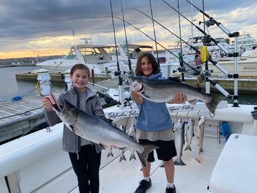 Two young teens holding 14 lb Coho Salmon and 15 lb King Salmon from Lake Michigan Charter Fishing