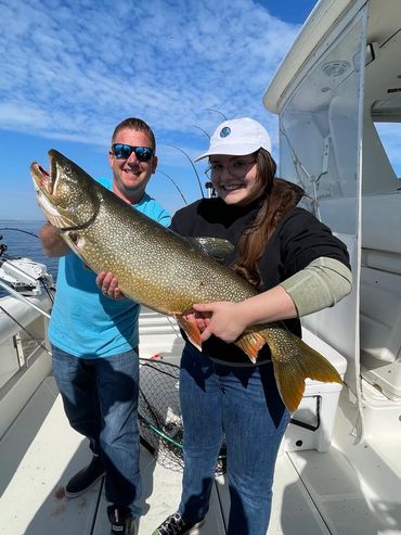 Teen girl holding massive Lake Trout caught during Lake Michigan Charter Fishing trip