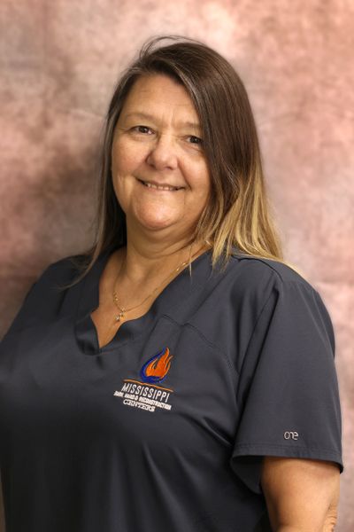 A woman smiling in a Mississippi Community College shirt.