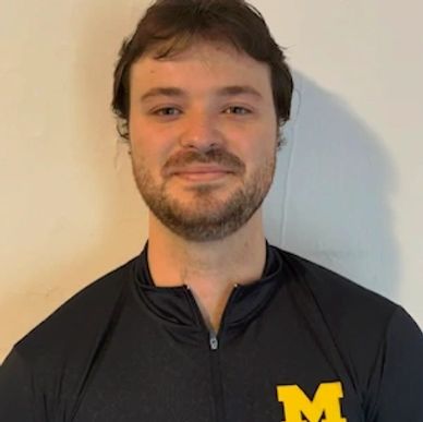 Young man wearing a black Michigan jacket with a yellow 'M' logo.