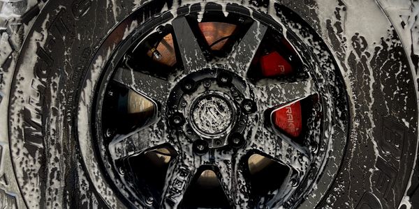 Soapy wheel and tire being detailed