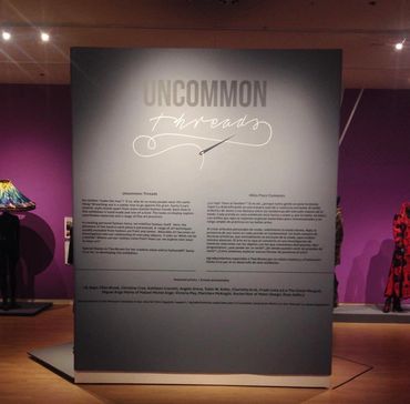 Exhibition panel titled 'Uncommon Threads' about fashion and art.