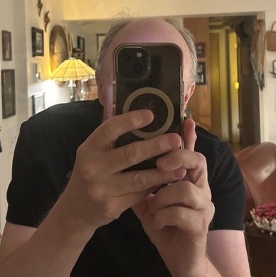 Darcy Kuronen taking a selfie with a cell phone camera, 2025