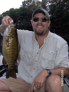 Ethan Raskind holding a live fish on a fishing tour