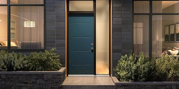 Modern blue front door with large windows and surrounding greenery.