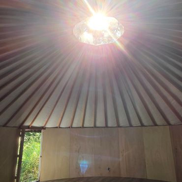 Sunlight streaming through a yurt's skylight.