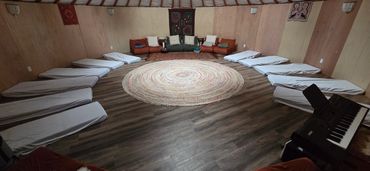 A circle of covered beds in a cozy, round room.