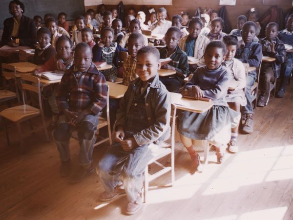 Children sitting attentively in a classroom.