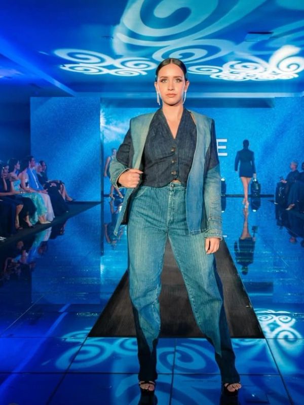 Modelo caminando en pasarela con ropa de mezclilla.