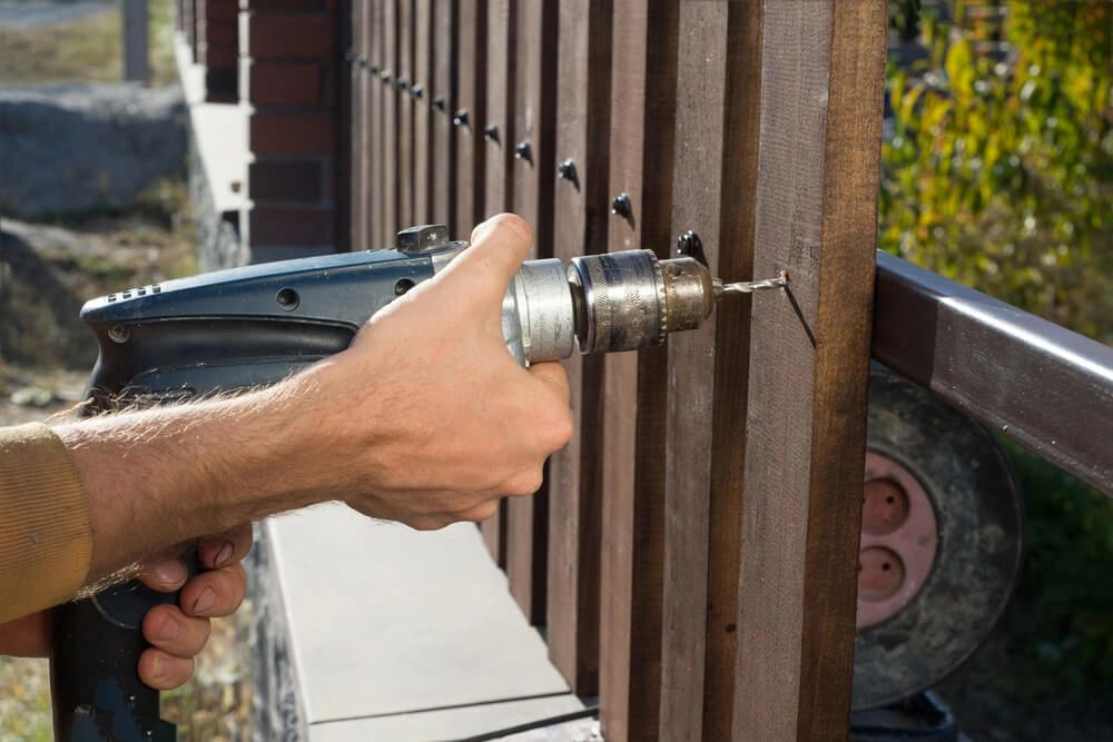 Building a wooden fence with a drill and screw