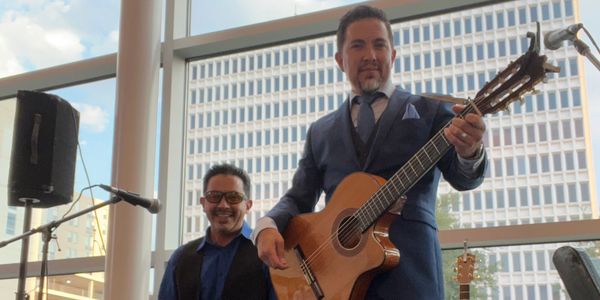 Two men performing music indoors, one playing guitar and the other on keyboard.