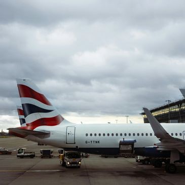 British Airways planes on the tarmac under a cloudy sky.