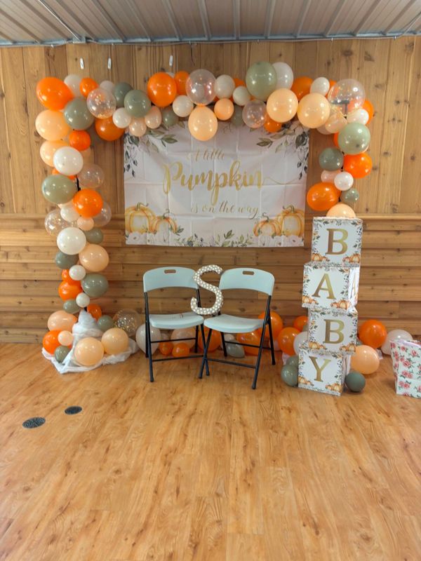 Autumn-themed baby shower setup with balloons and decorations.