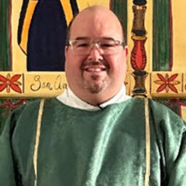 Smiling man in green religious robe.
