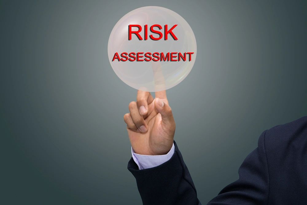 A  person pointing to a circle containing the words "Risk Assessment 
