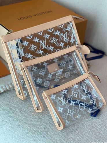Set of three transparent Louis Vuitton pouches with beige trim.
