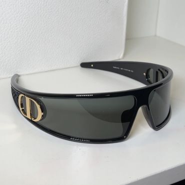 Black Dior sunglasses with gold logo on the side.