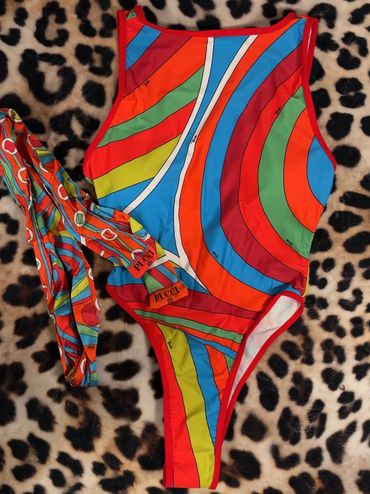 Colorful striped swimsuit with matching headband on leopard print background.