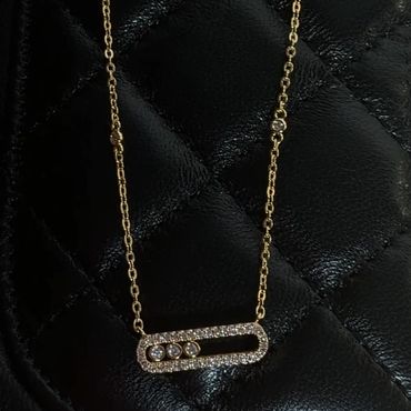 Gold necklace with diamond-embellished rectangular pendant.