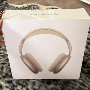 Box of gold-colored AirPods Max headphones on a furry surface.