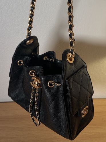 Elegant black Chanel handbag with gold chain strap.