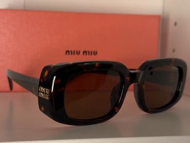Stylish Miu Miu tortoiseshell sunglasses with brown lenses.
