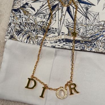 Gold necklace with DIOR letters and a Christian Dior pouch.