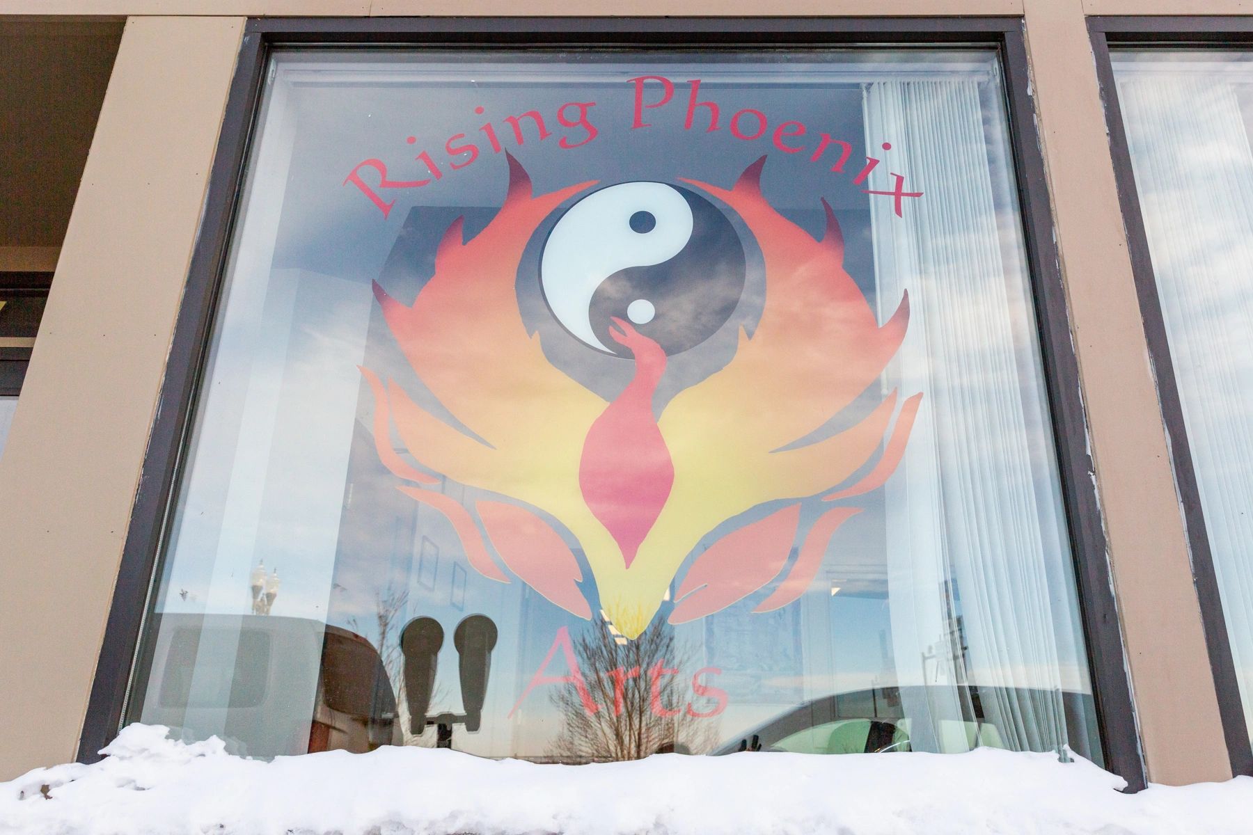 The Rising Phoenix Martial Arts logo on a window