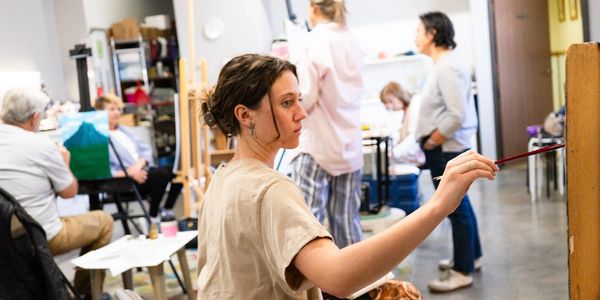 This is an image of a student painting with oil paint in our adult fine art class.